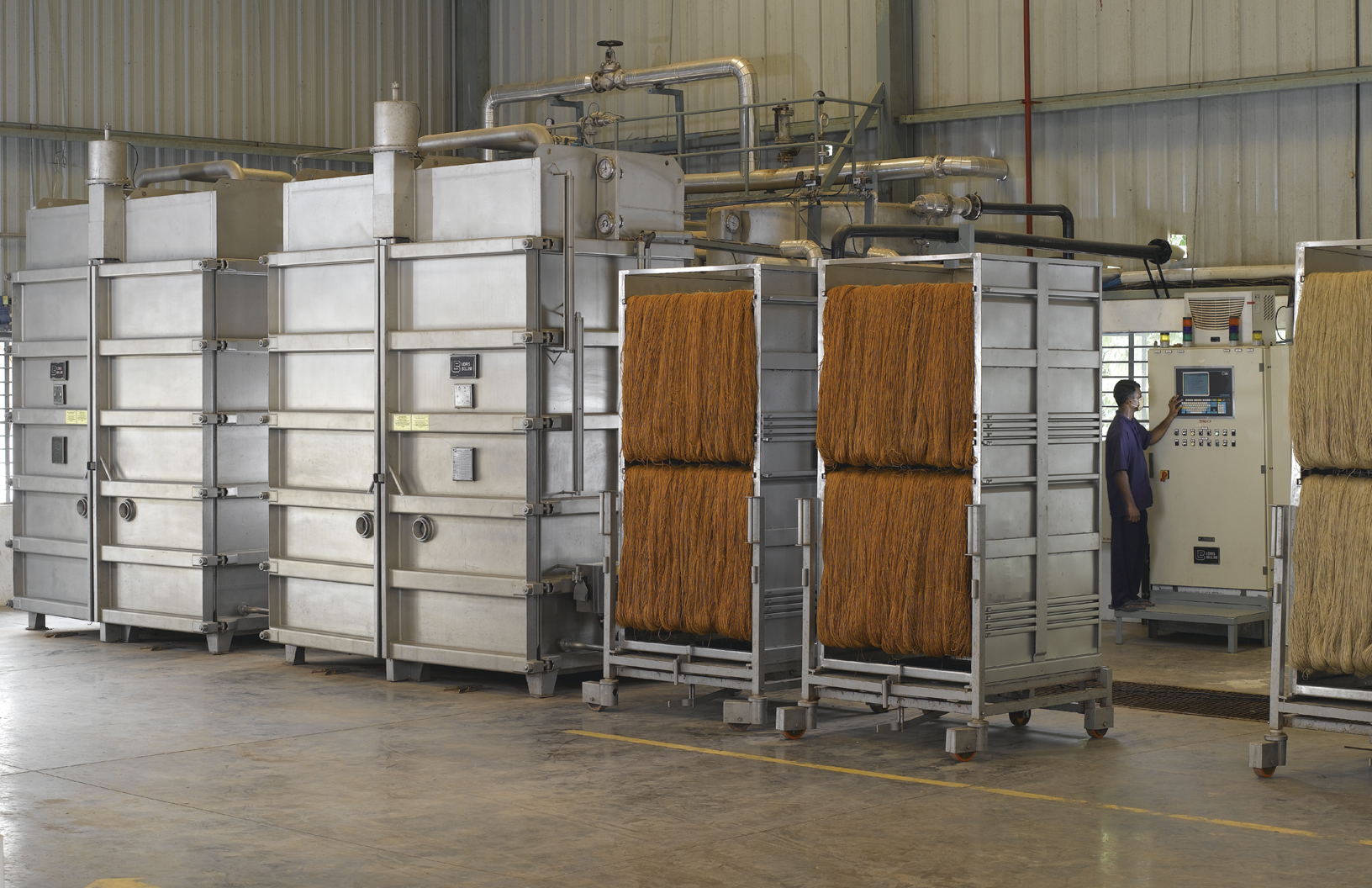 A craftsman using a gun tufting tool on a large piece of fabric.