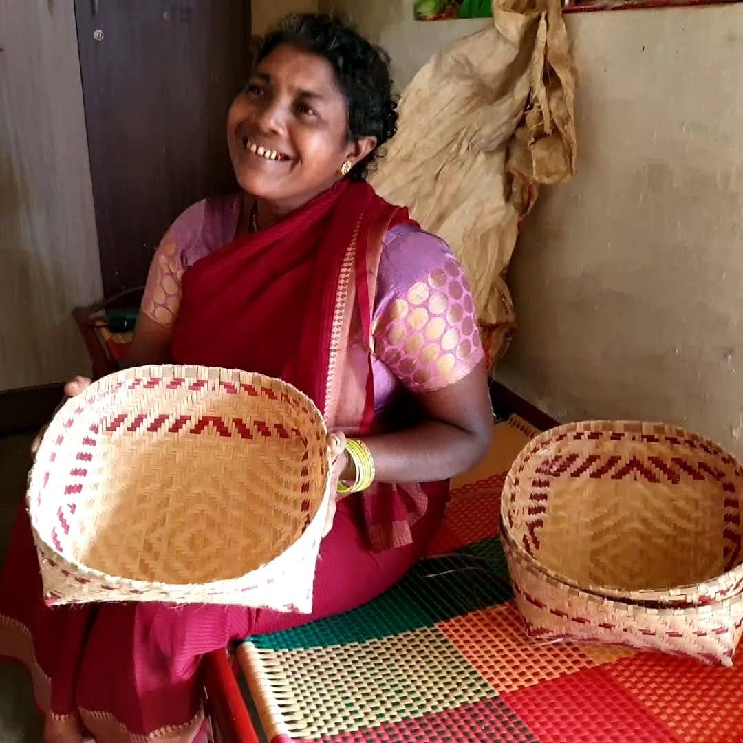 Close-up of a hand weaving a colorful textile on a loom.